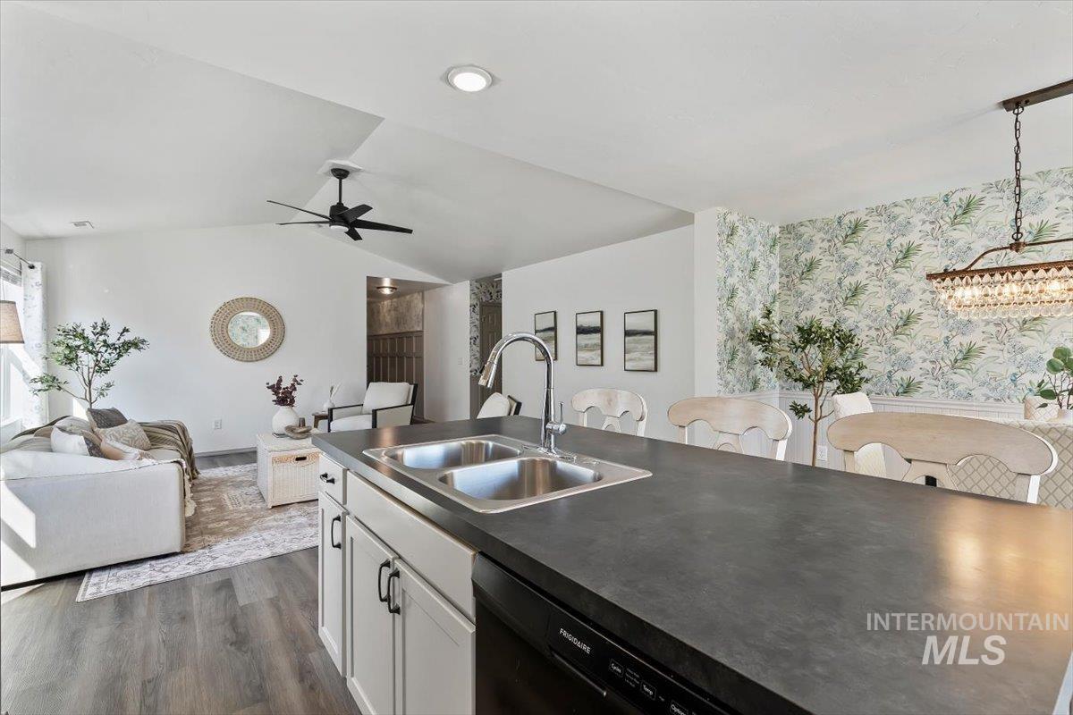12781 Ashfield Street Caldwell, ID 83607 - Photo 35 of 36 Kitchen featuring open floor plan, black dishwasher, dark wood-type flooring, white cabinetry, and dark countertops