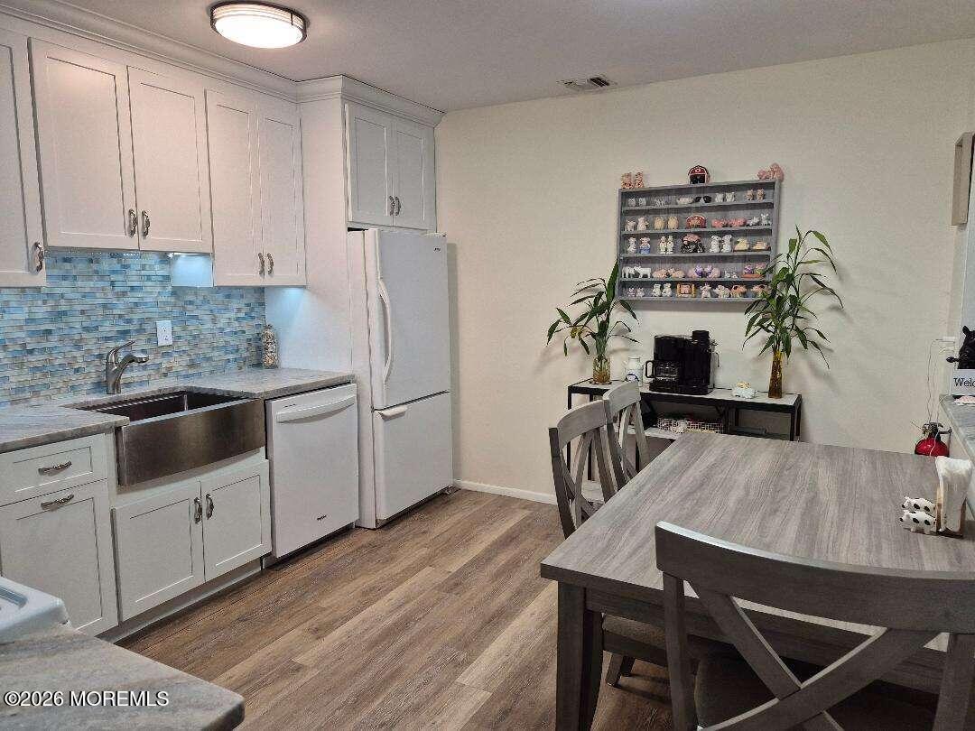 27 B Cedar Street Toms River, NJ 08757 - Photo 4 of 14 a kitchen with stainless steel appliances kitchen island a table chairs in it and white cabinets