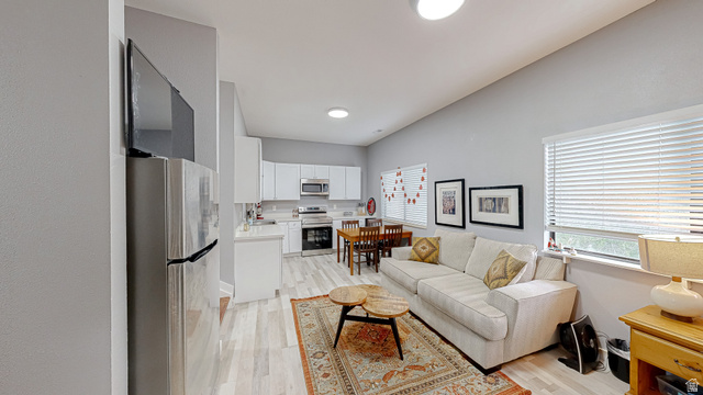 630 1100 West Provo, UT 84601 - Photo 6 of 64 Open-concept living space featuring wood-finish flooring, recessed lighting, and a kitchen with white cabinetry and stainless steel appliances
