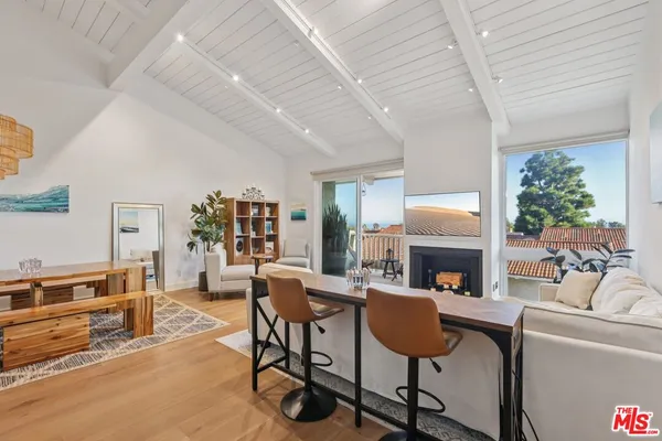 a living room with furniture a fireplace and a floor to ceiling window