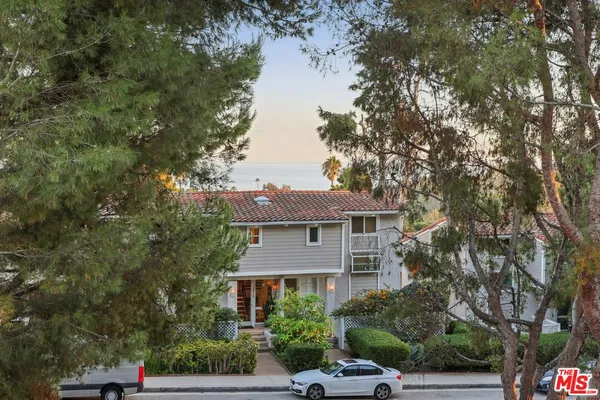 a front view of a house with a yard and tree s