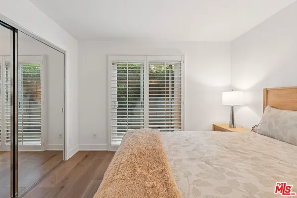 a bedroom with a bed and a large window