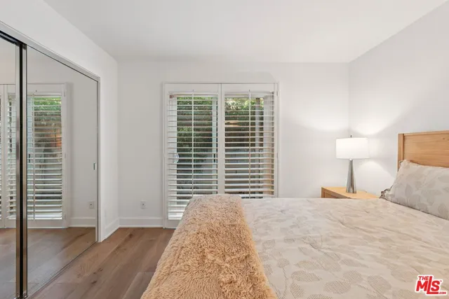 a bedroom with a bed and a large window