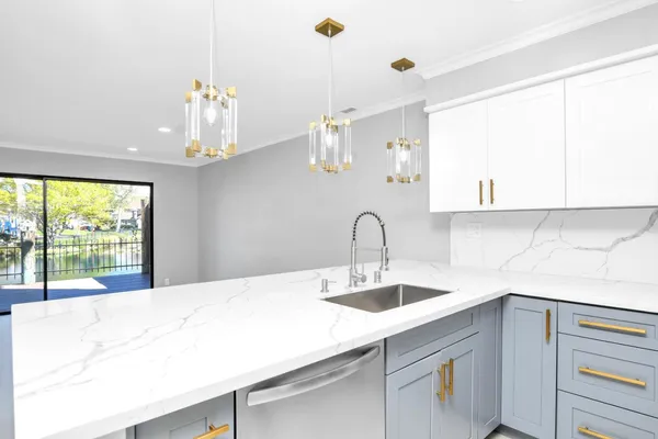 a large kitchen with stainless steel appliances a large counter top a stove a refrigerator and a sink