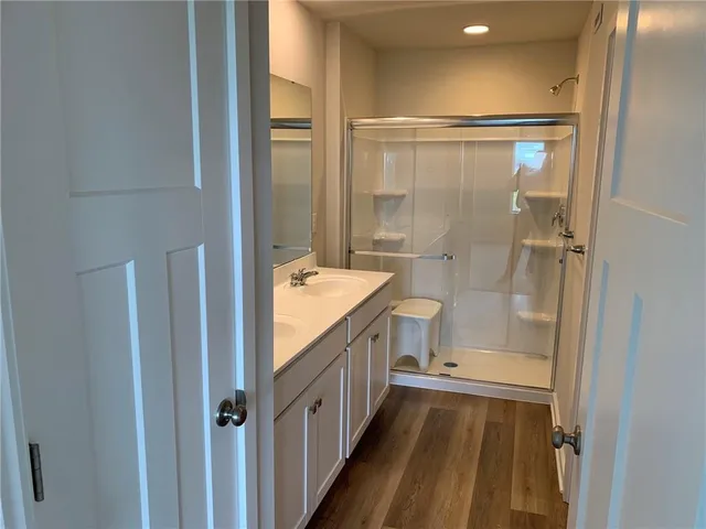 a bathroom with a granite countertop sink a toilet and shower