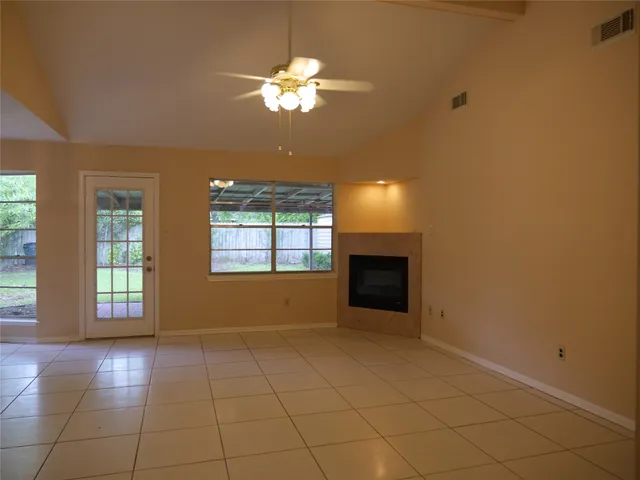 an empty room with chandelier and windows