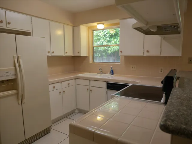 a kitchen with a sink cabinets and a window