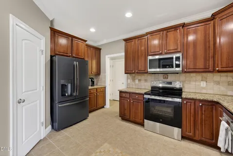 a kitchen with stainless steel appliances granite countertop wooden cabinets a stove top oven a sink and dishwasher