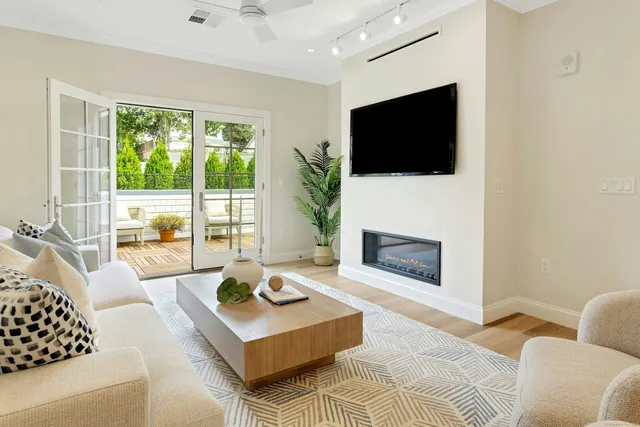 a living room with furniture a flat screen tv and a fireplace