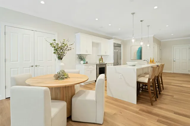 a dining room with furniture a chandelier and kitchen view