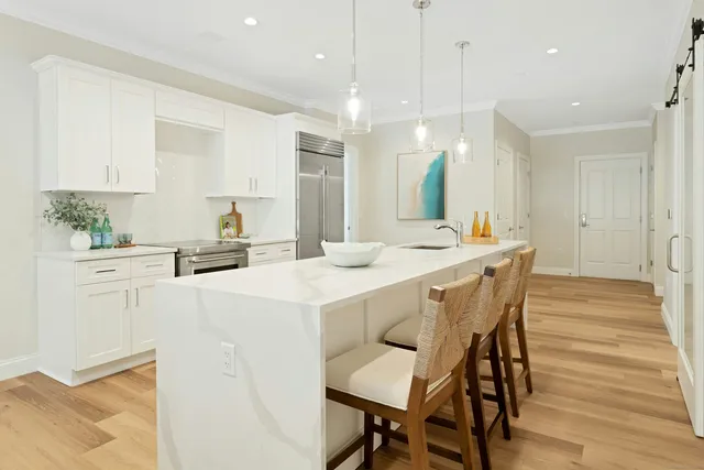 a dining table chairs and white cabinets