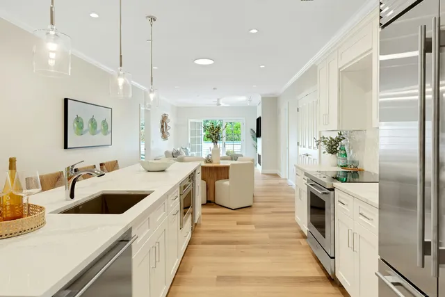 a large kitchen with kitchen island a large counter top a sink a stove and a refrigerator