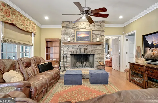 a living room with furniture a large window and gym equipment