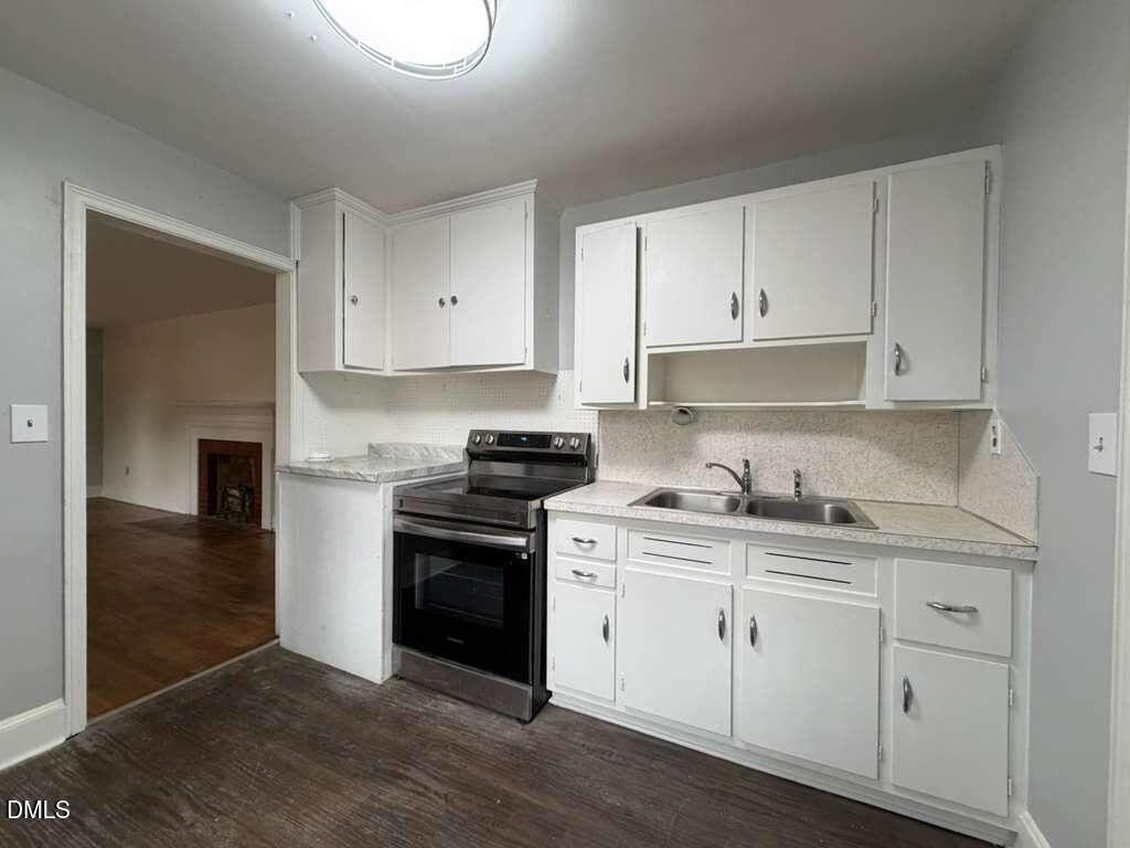1419 Leon Street Durham, NC 27705 - Photo 16 of 23 a kitchen with granite countertop white cabinets and stainless steel appliances