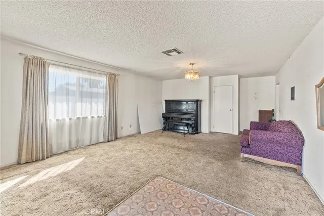 a large bedroom with a bed and a view of living room