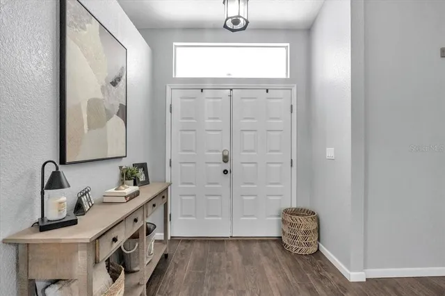 a bathroom with a sink a mirror and wooden floor