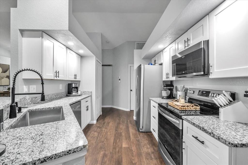 29350 Goodhue Street Punta Gorda, FL 33982 - Photo 10 of 21 a kitchen with stainless steel appliances granite countertop a sink stove microwave and refrigerator