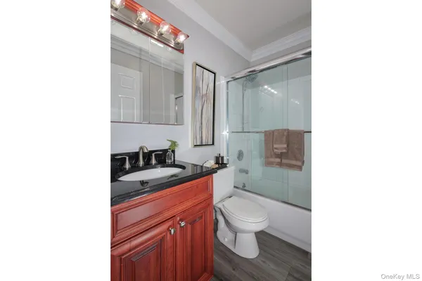 a bathroom with a sink toilet vanity and shower