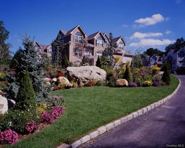 a view of a house with a big yard and potted plants