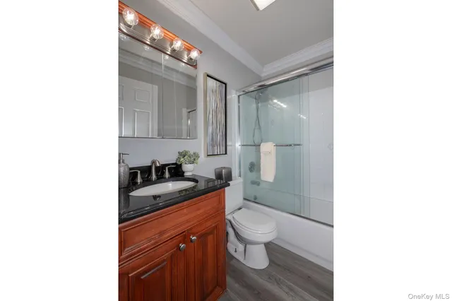 a bathroom with a granite countertop sink a toilet and shower