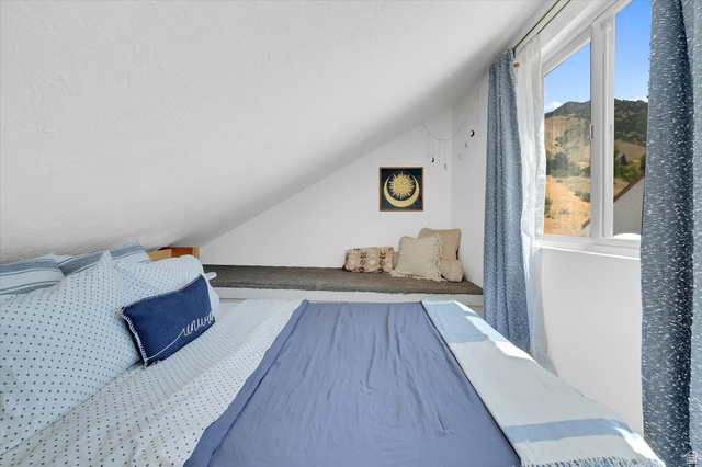 510 Spring Creek Road Providence, UT 84332 - Photo 20 of 97 Sloped ceiling room featuring a large window, a built-in window seat, and mountain scenery