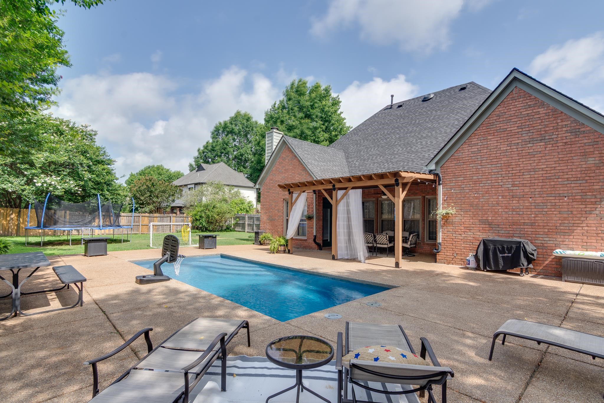 779 Early Earner Cove Collierville, TN 38017 - Photo 24 of 29 Expansive backyard featuring a rectangular in-ground swimming pool, a concrete patio, and a wood pergola with privacy drapes