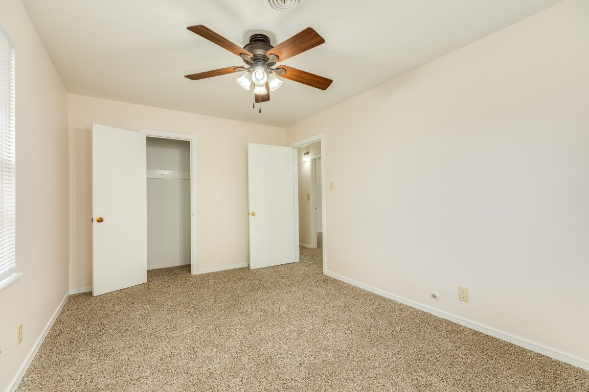 837 Pin Money Street Clute, TX 77531 - Photo 21 of 24 an empty room with a chandelier fan and windows