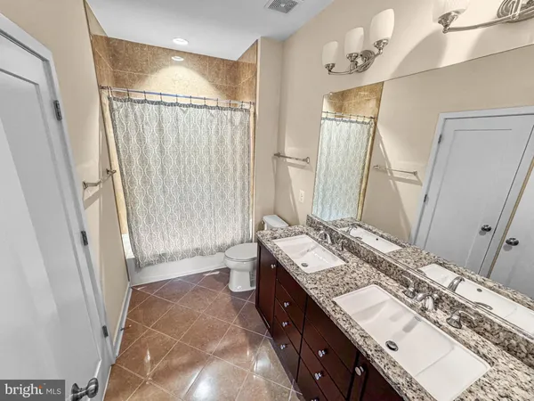 a spacious bathroom with a double vanity sink and a mirror