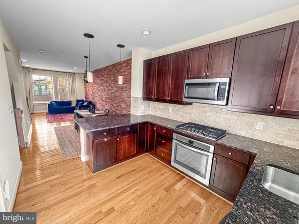 a kitchen with stainless steel appliances granite countertop wooden cabinets a stove top oven a sink and dishwasher