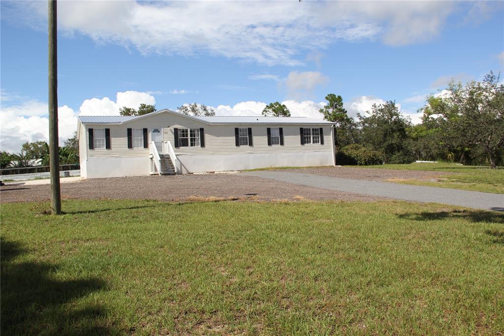 13127 Star Road Brooksville, FL 34613 - Photo 2 of 54 a front view of a house with a garden