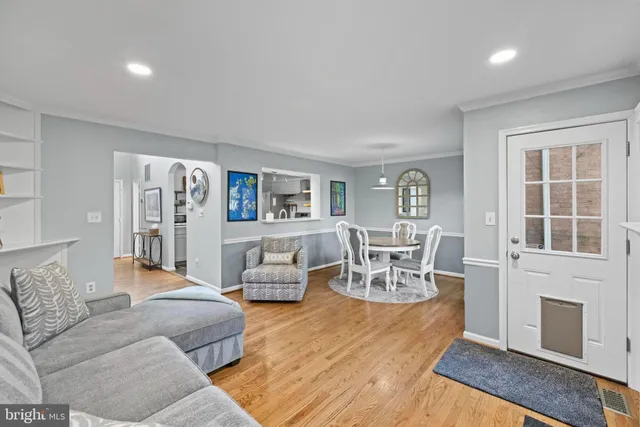 a living room with furniture and a dining table with kitchen view