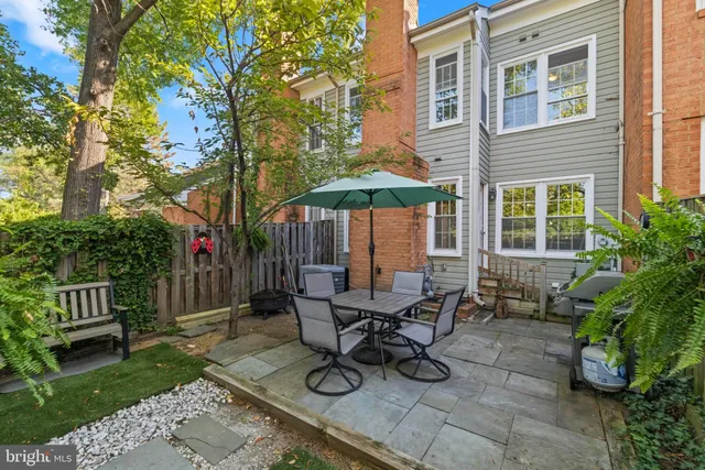 a view of a dinning table and chairs in backyard of the house