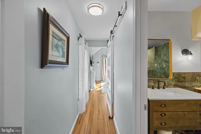 a view of bathroom with a sink mirror and window