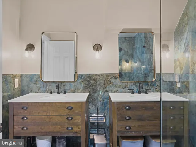 a bathroom with a double vanity sink mirror and shower