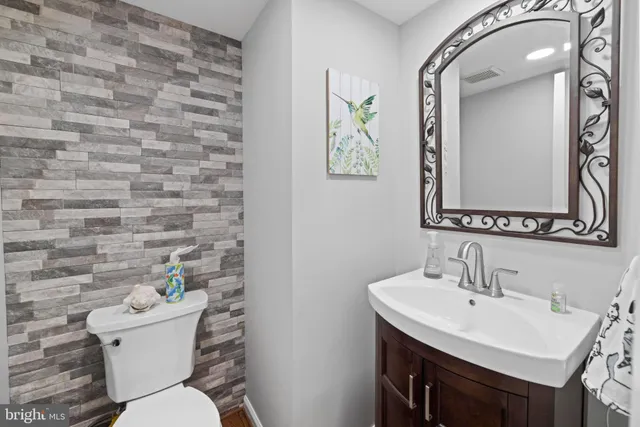 a bathroom with a toilet a sink and mirror