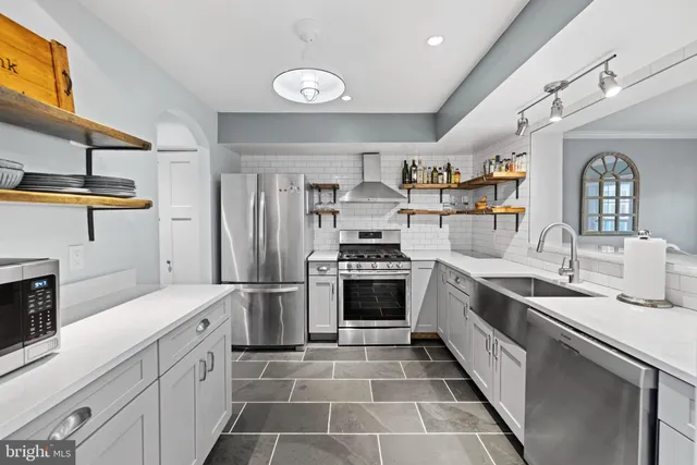 a kitchen with stainless steel appliances granite countertop a sink and stove top oven