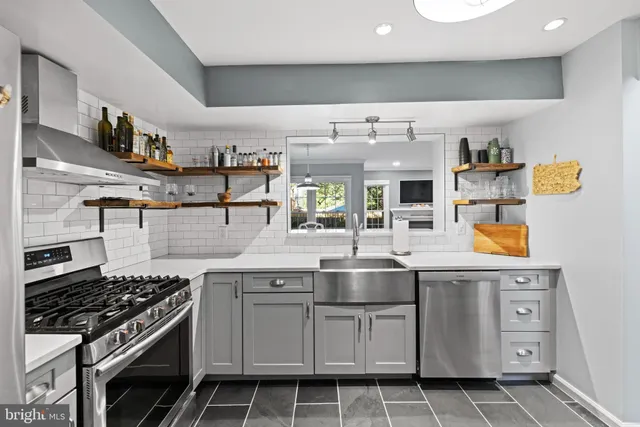 a kitchen with stainless steel appliances granite countertop a sink and cabinets