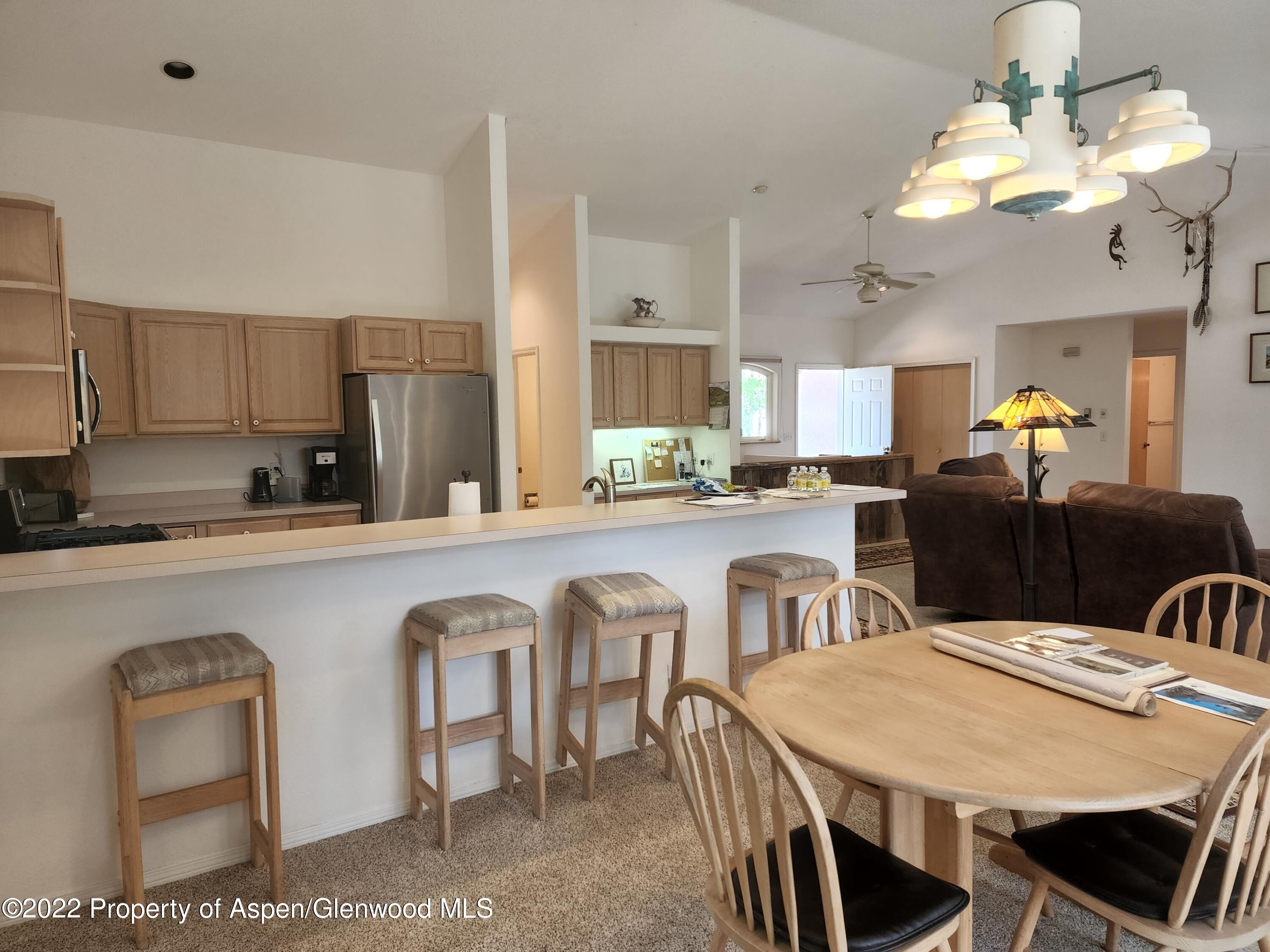 751 Latigo Loop Carbondale, CO 81623 - Photo 17 of 44 a kitchen with stainless steel appliances granite countertop a dining table chairs and a refrigerator