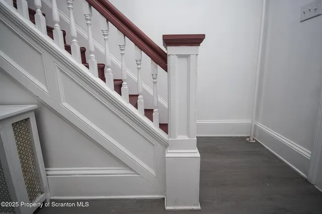 a view of staircase with lots of frames on wall and a large window