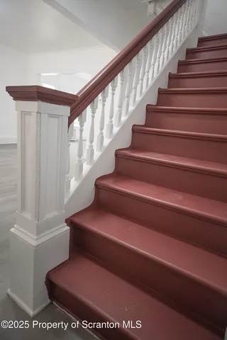 a bathroom with stairs and a rug