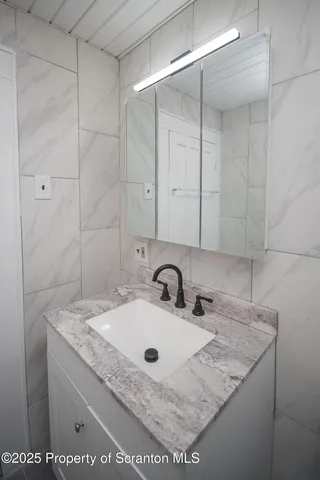 a bathroom with a granite countertop sink and mirror