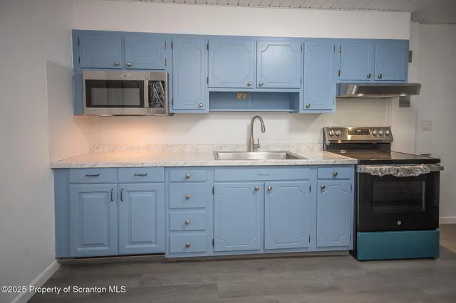 a kitchen with granite countertop white cabinets and stainless steel appliances
