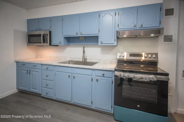 a kitchen with granite countertop white cabinets and stainless steel appliances