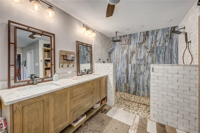 a bathroom with a double vanity sink mirror and shower