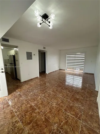 a view of empty room with a kitchen