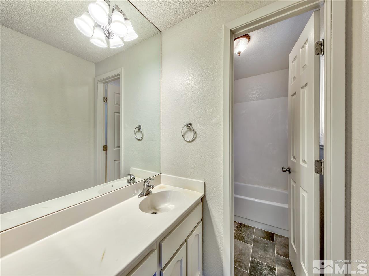 7460 Berryhill Drive Reno, NV 89511 - Photo 14 of 23 a bathroom with a sink a light fixture and a mirror