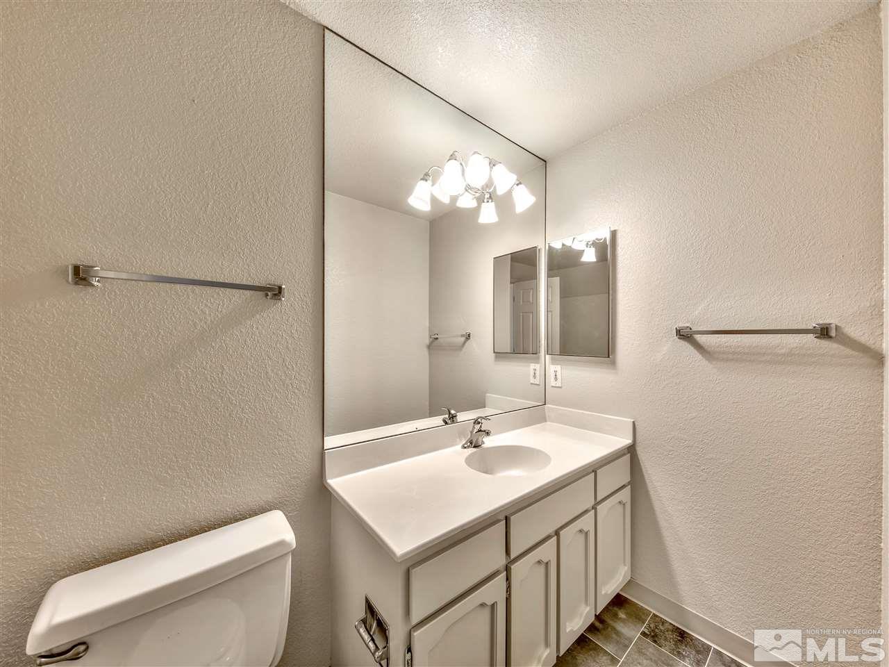 7460 Berryhill Drive Reno, NV 89511 - Photo 16 of 23 a bathroom with a sink a toilet and mirror