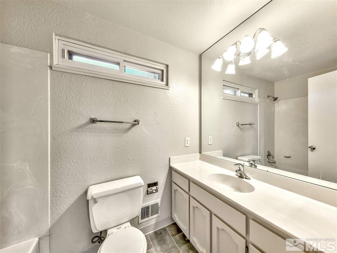 7460 Berryhill Drive Reno, NV 89511 - Photo 23 of 23 a bathroom with a toilet sink and mirror