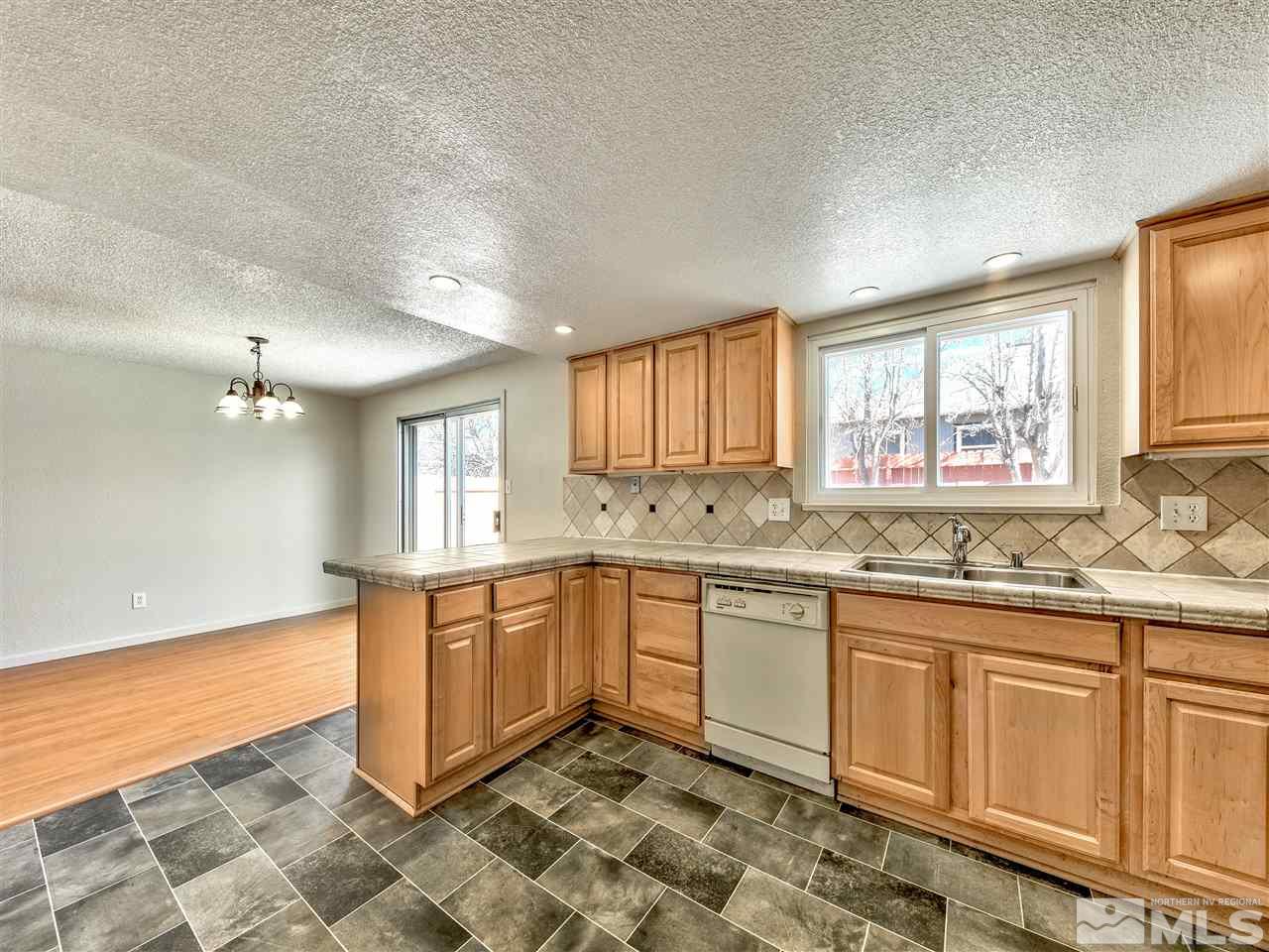 7460 Berryhill Drive Reno, NV 89511 - Photo 7 of 23 a large kitchen with granite countertop a sink and dishwasher a stove with wooden cabinets