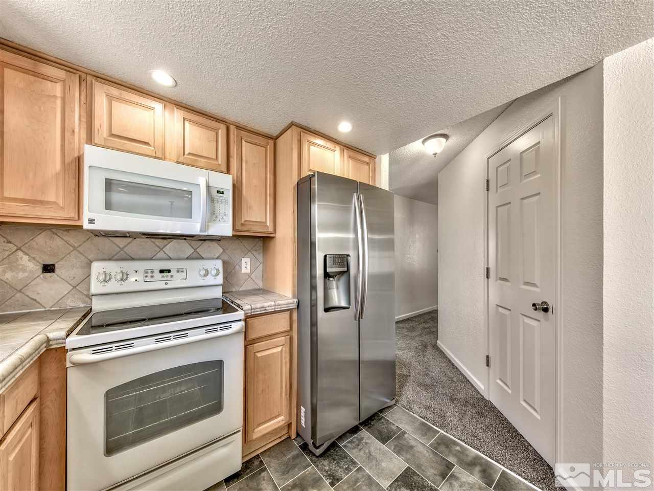 7460 Berryhill Drive Reno, NV 89511 - Photo 8 of 23 a kitchen with a stove microwave and refrigerator